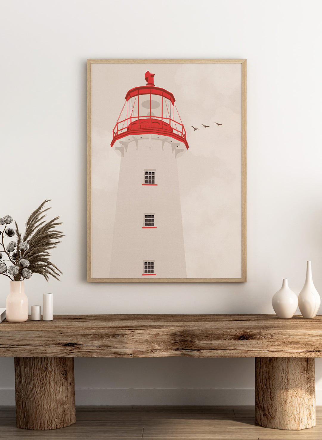 A stylized art print of a lighthouse with a white tower, a red lantern room, and a red lightning rod, set against a warm beige sky with three flying birds.  Coastal Red Lighthouse by Lisa Solomoniuk premium framed fine art print featuring a white lighthouse with bright red details beneath a pale coastal sky.