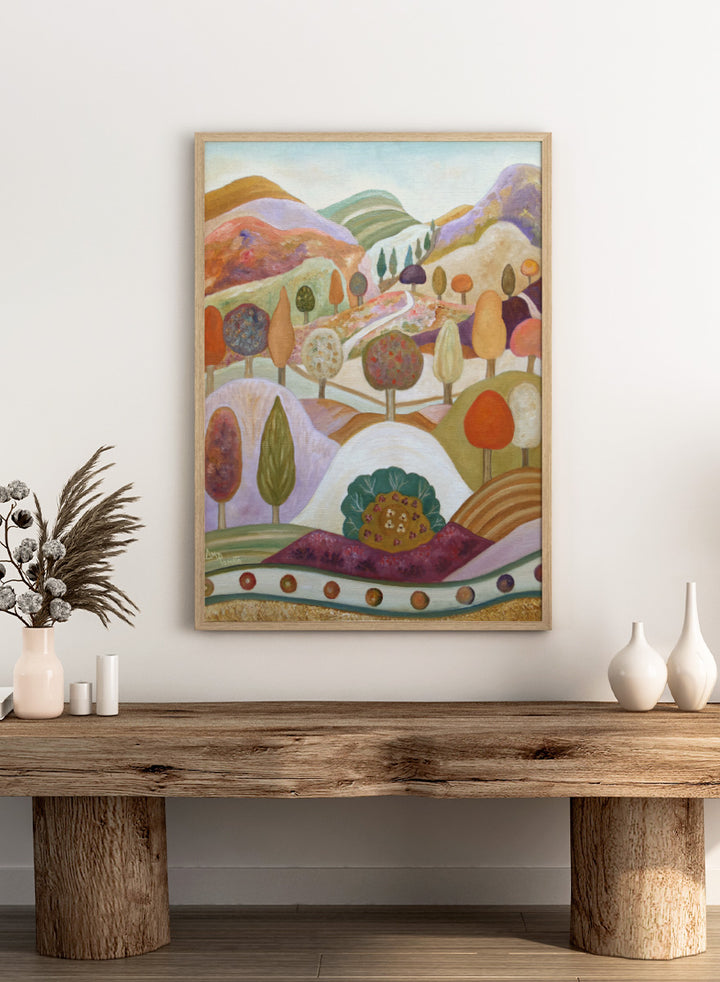 A colorful landscape painting featuring stylized hills, rolling hills, and trees in pastel and earthy tones. Shop Whimsical Autumn Landscape by Angeles M. Pomata, a colorful fall landscape art print featuring rolling hills, winding paths, and stylized autumn trees.