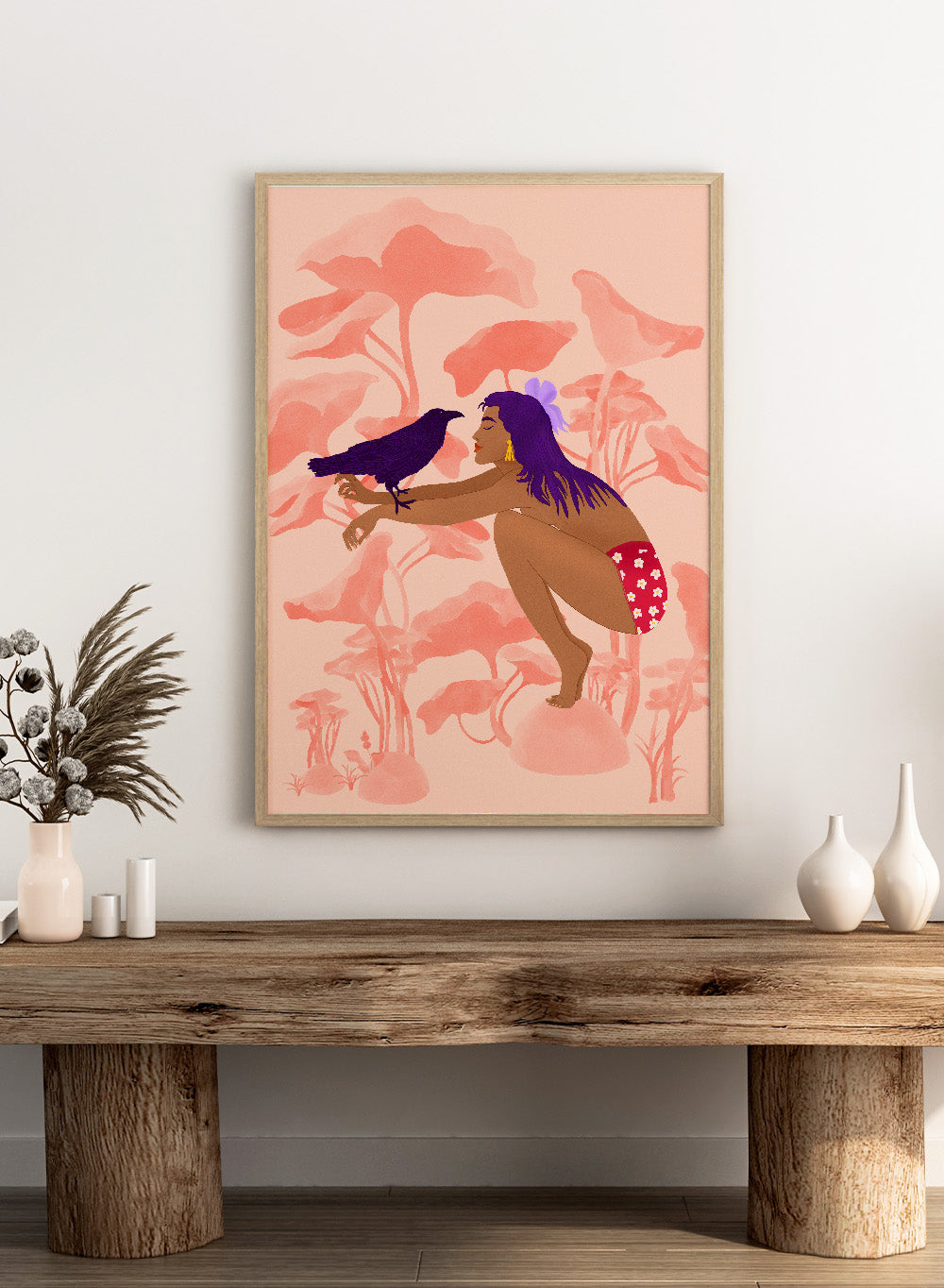 Illustration of a woman with a bird on a pink floral background. Raven by Jota de Jai is a modern pink wall art print of a woman with a purple raven, available as a premium fine art poster with optional wood framing.