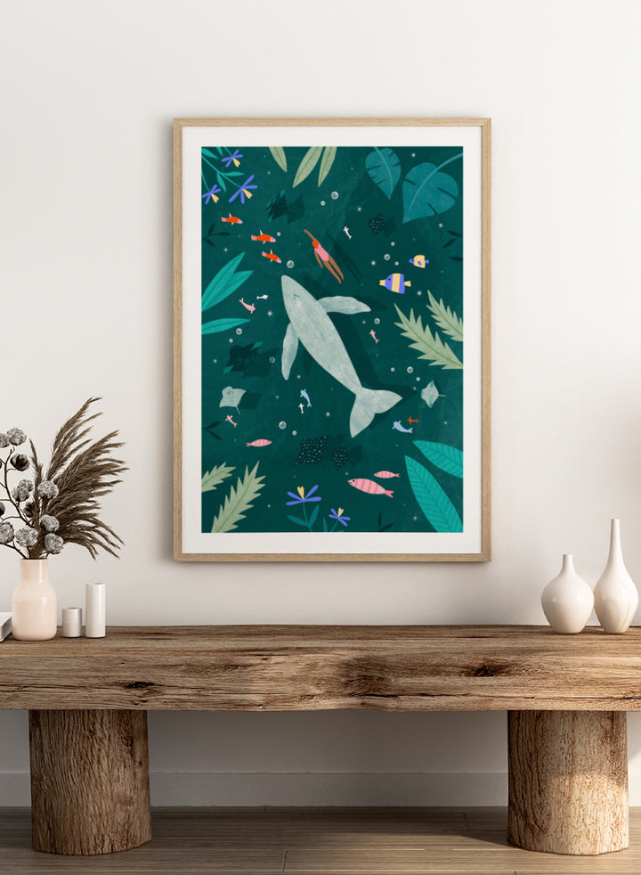 Shop Peaceful Ocean Encounter by Bea Müller, an ocean wall art print poster featuring a swimmer, whale, tropical fish, and whimsical underwater scenery in teal.