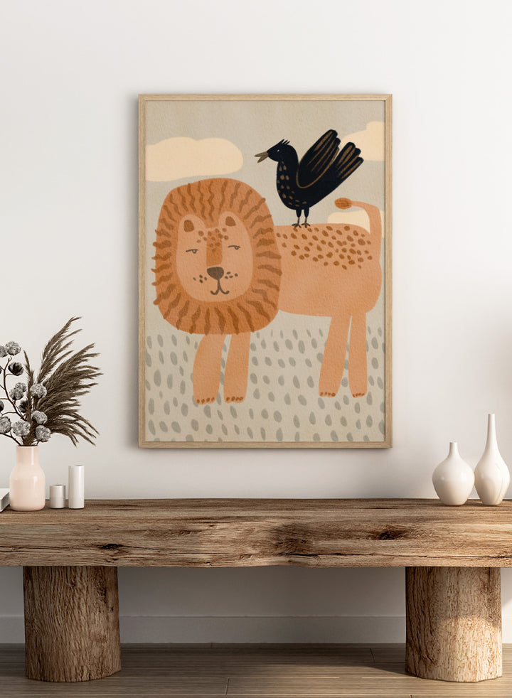 A stylized illustration of a lion and a crow on a cream background with clouds and dotted ground. The lion is tan and peach with brown stripes in its mane, and the crow is black with small gold spots. Shop Friendly Lion And Bird by Nikita Jariwala, a nursery wall art print poster with a lion, bird, animal illustration, and beige tones.