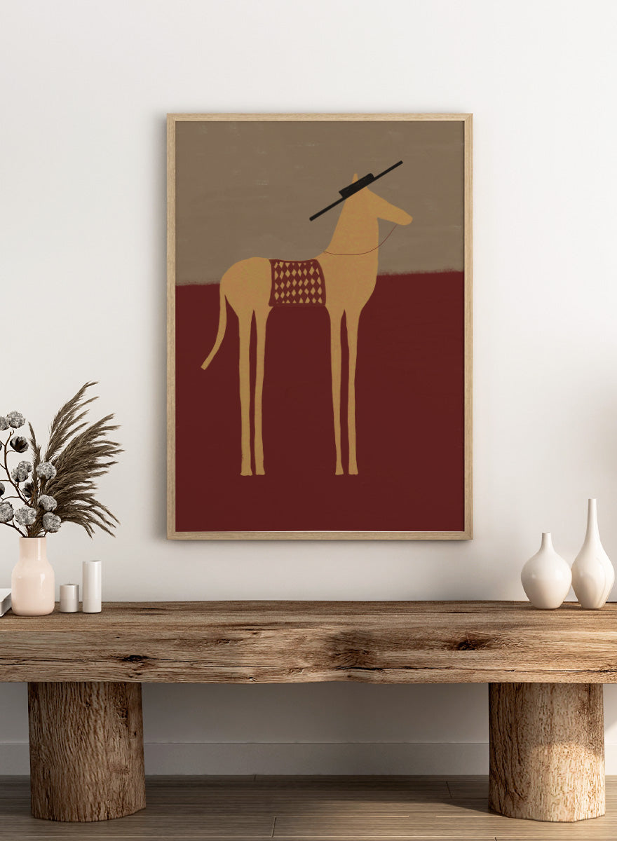 A stylized art print of a camel standing in profile, with a dark hat on its head and a patterned saddle blanket, set against a split beige and dark red background. Desert Horse with Sombrero by The Art Concept animal art print featuring a long-legged horse, patterned saddle blanket, black sombrero, and warm desert tones.