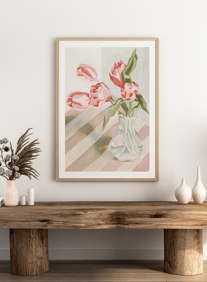 Artistic depiction of pink tulips in a clear vase on a striped background. Tulips in a Vase by Lucrecia Caporale is an officially licensed still life art print featuring pink tulips in a glass vase. Available framed or unframed.