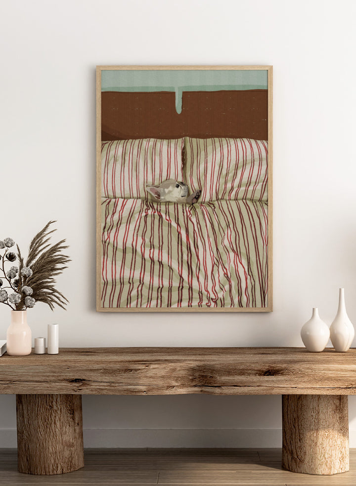 A cozy bed setup with beige and red striped bedding, two matching pillows, and a small gray cat curled up on the duvet. The background features a brown textured headboard and a mint green wall at the top. Shop Cozy Dog in Bed by Lisa Solomoniuk, a playful dog animal art print featuring a pup tucked into striped bedding with a warm, cozy bedroom feel.