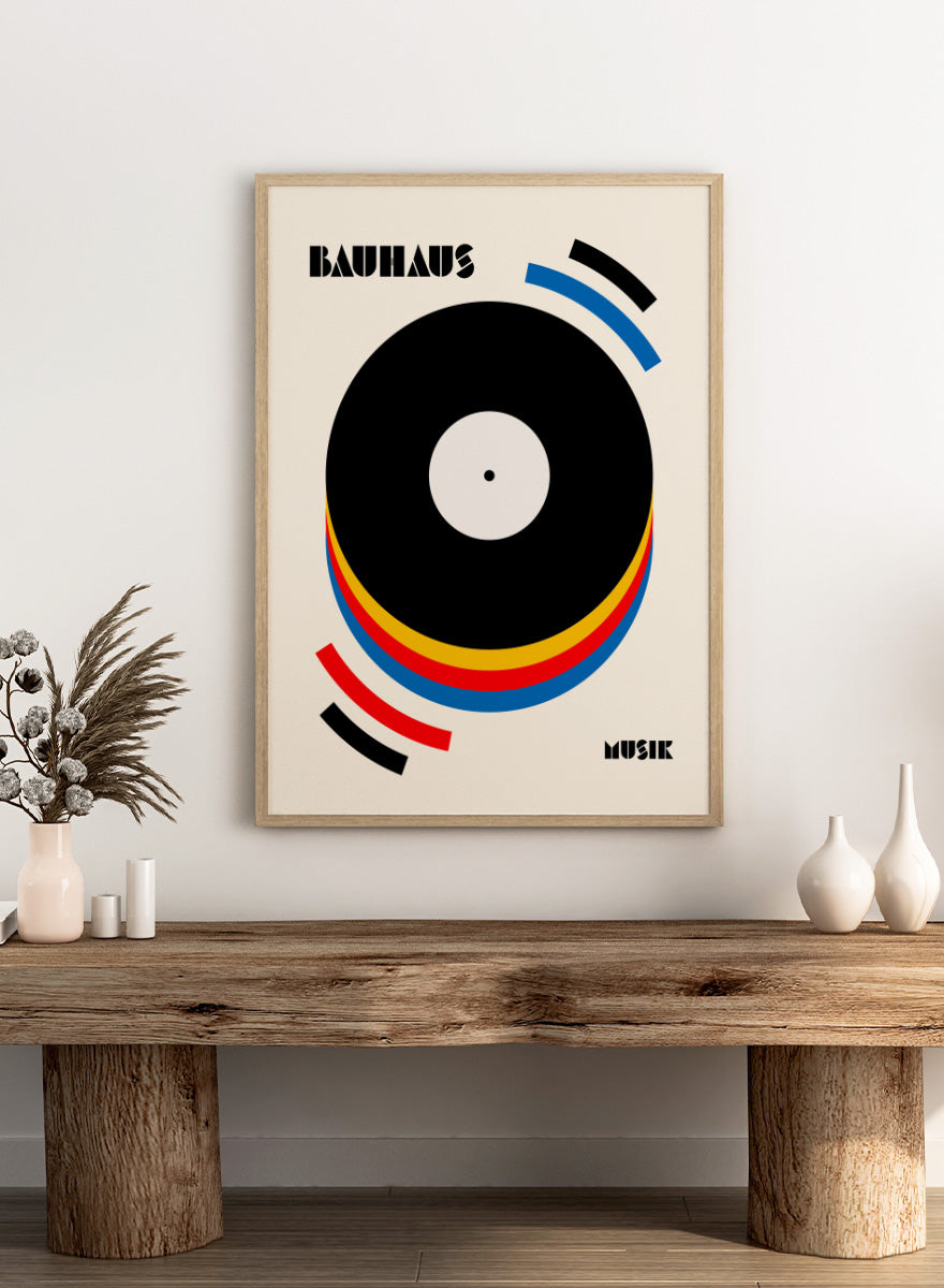 A Bauhaus-style poster featuring a large black vinyl record graphic with concentric red, yellow, and blue rings on a warm cream background, with the words &
