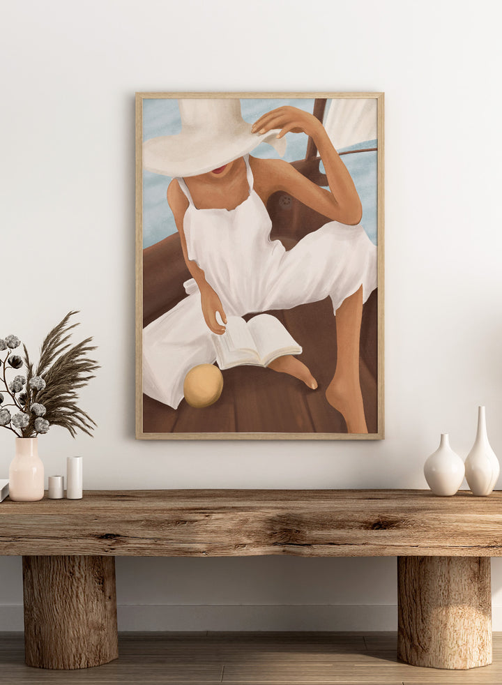 Woman in a white dress and hat reading a book on a boat. Summer Boat Reading by City Art is a modern coastal art print featuring a woman reading on a boat in a white dress, surrounded by blue water and warm wood.