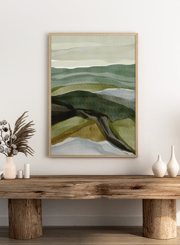 Shop Serene Green Landscape by Nikita Jariwala, a modern abstract landscape art print featuring layered hills, rolling countryside, and soft green, olive, gray, and blue tones.