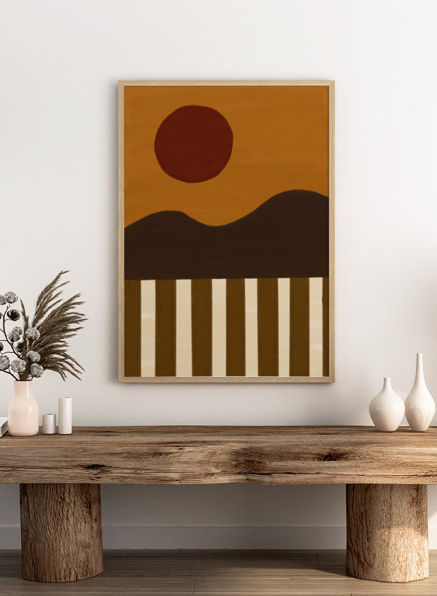 A minimalist abstract landscape art print featuring a dark brown sun over a wavy horizon, with vertical brown and cream stripes at the bottom. Minimalist Desert Sun by The Art Concept landscape art print featuring a red sun, dark rolling hills, warm ochre tones, and bold vertical stripes.