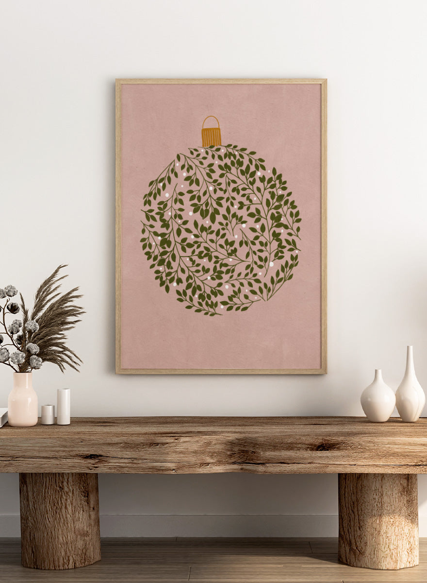 Shop Round Ornament by Katie O’Shea, a botanical Christmas wall art print poster featuring green leaves, white glowing light details, and a dusty pink background.