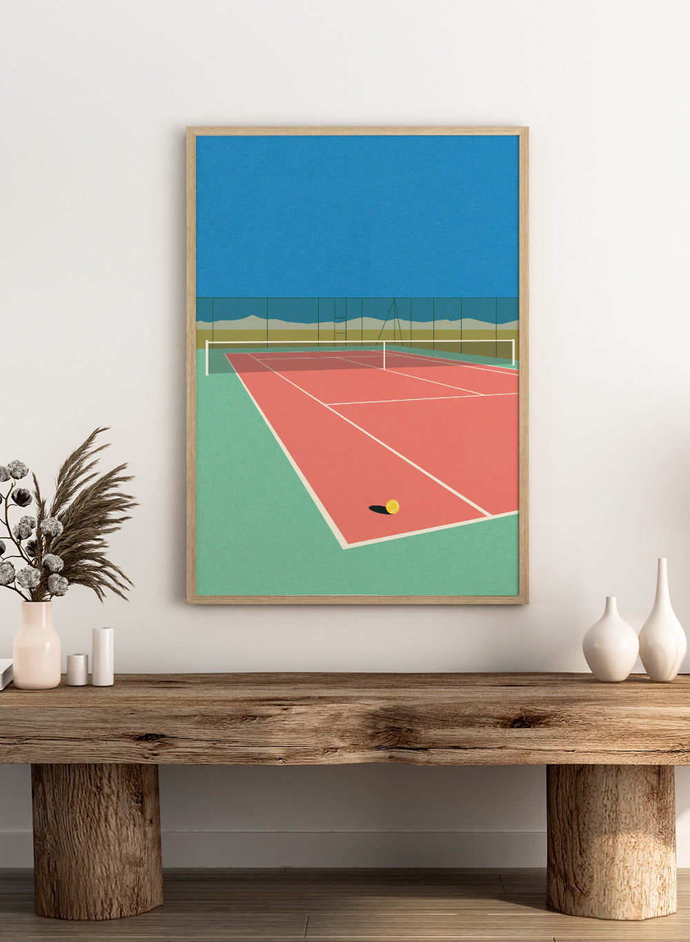 Illustration of a tennis court with a ball on the ground and mountains in the background. Tennis Court in the Desert by Rosi Feist is a modern minimalist fine art print of a pink tennis court in a surreal desert landscape. Officially licensed wall poster with optional artisan framing.