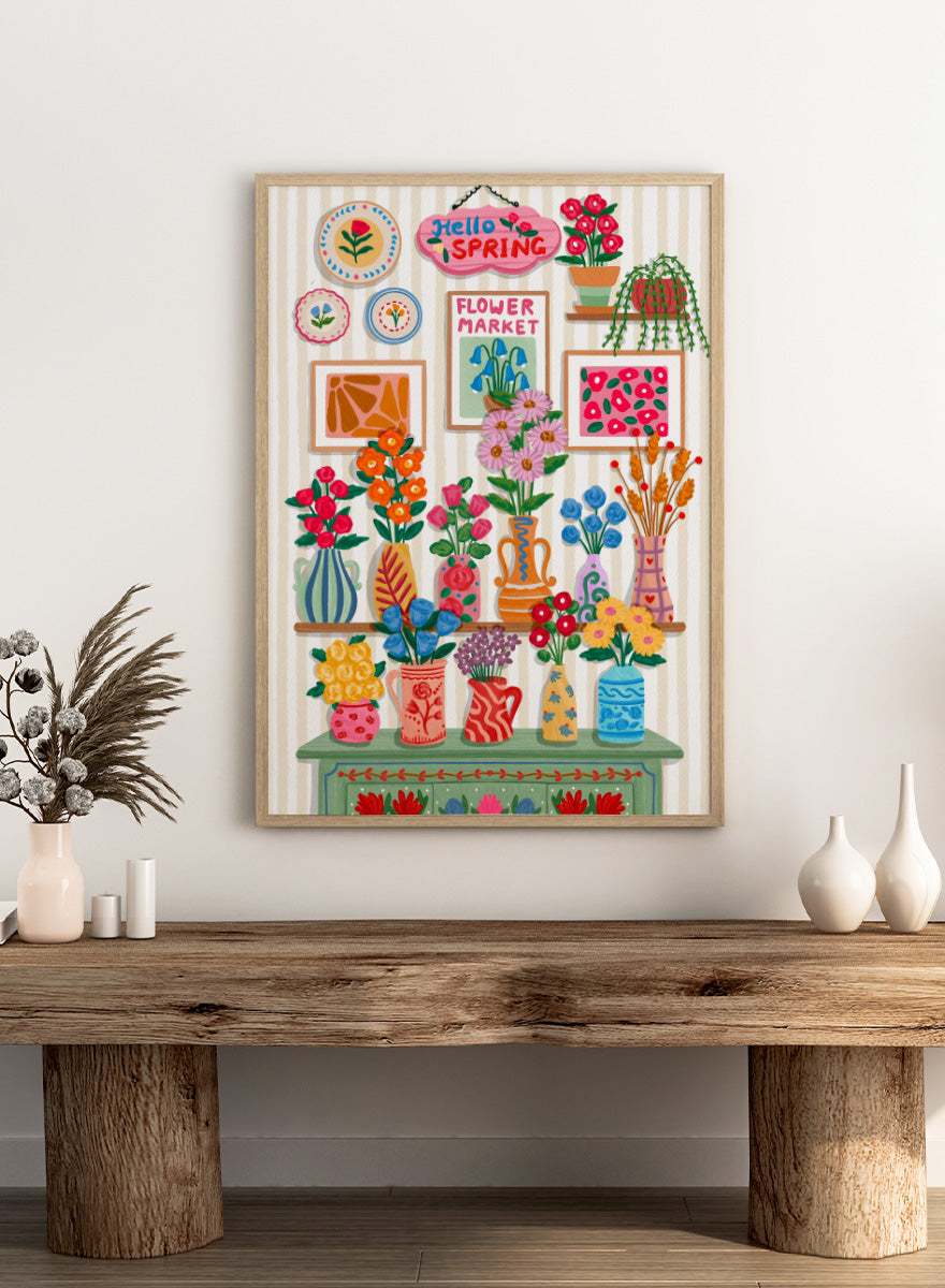 A colorful spring-themed floral wall display illustration featuring vases, framed art, hanging plants, and a sign reading &