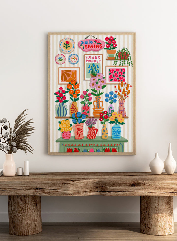 A colorful spring-themed floral wall display illustration featuring vases, framed art, hanging plants, and a sign reading &