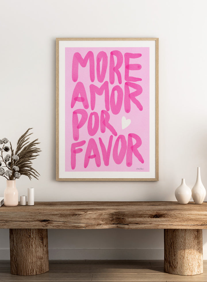 Pink text 'More Amor Por Favor' with a heart on a pink background. More Amor Por Favor by Baroo Bloom features bold pink hand-painted typography and a playful love message. Officially licensed wall poster with optional framing.