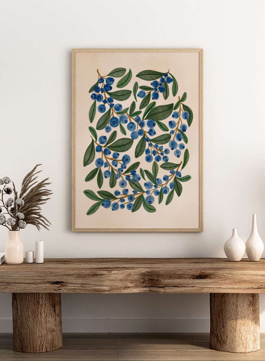 Botanical art print of blueberry branches with green leaves on a warm beige background. Shop Fresh Blueberry Sprigs by Nikita Jariwala, a botanical wall art print poster featuring blueberry branches, deep blue berries, and leafy green summer detail.