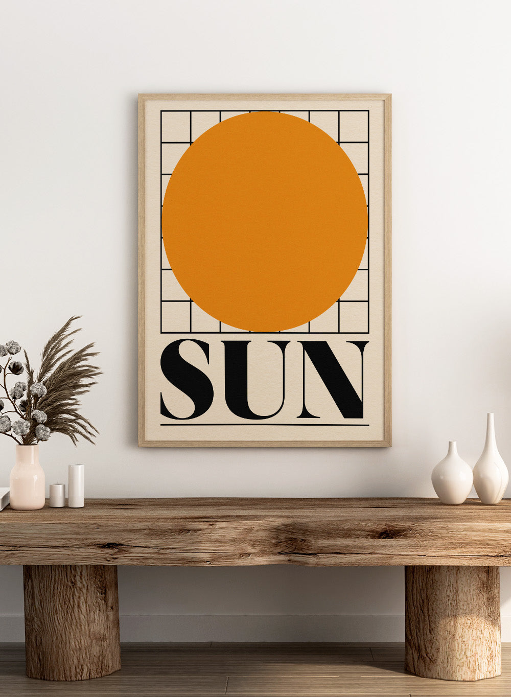 Poster with a large orange circle and the word 'SUN' on a beige background. Sun by Rosi Feist is a bold minimalist Bauhaus-inspired art print featuring an orange circle and graphic grid. Officially licensed modern poster with framing.
