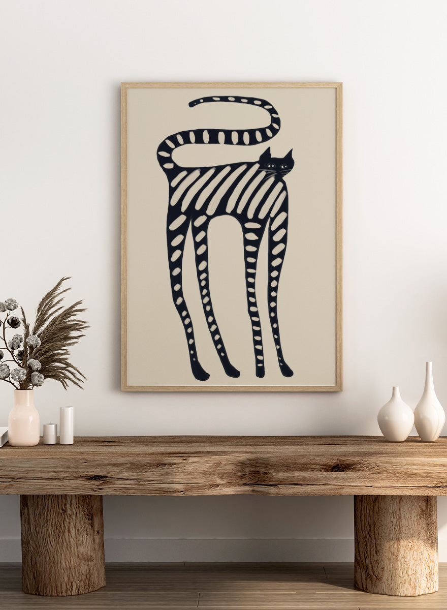 A stylized black cat illustration with bold diagonal stripes and white oval spots on a warm beige background. Striped Whimsical Cat by The Art Concept playful cat art print featuring an elongated black cat with cream stripes and an oversized looping tail.