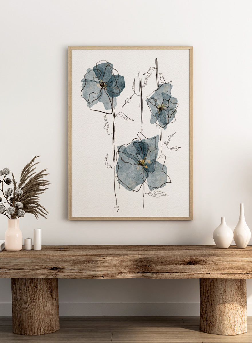 A framed watercolor and ink floral art print featuring three blue-gray flowers with black sketch lines on a white textured background. Shop Delicate Blue Blooms by Ankie Kooi, a modern floral wall art print poster featuring abstract watercolor flowers, botanical line art, blue, cream, and black.