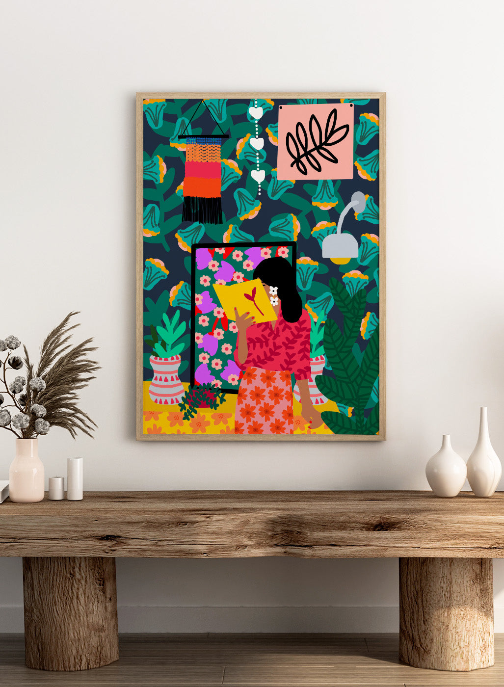 Colorful illustration of a woman reading a book with a vibrant patterned background. In Her Own Pages by Rafaela Mascaro fine art print featuring woman reading book, bold floral wallpaper, botanical interior, modern wall art poster.