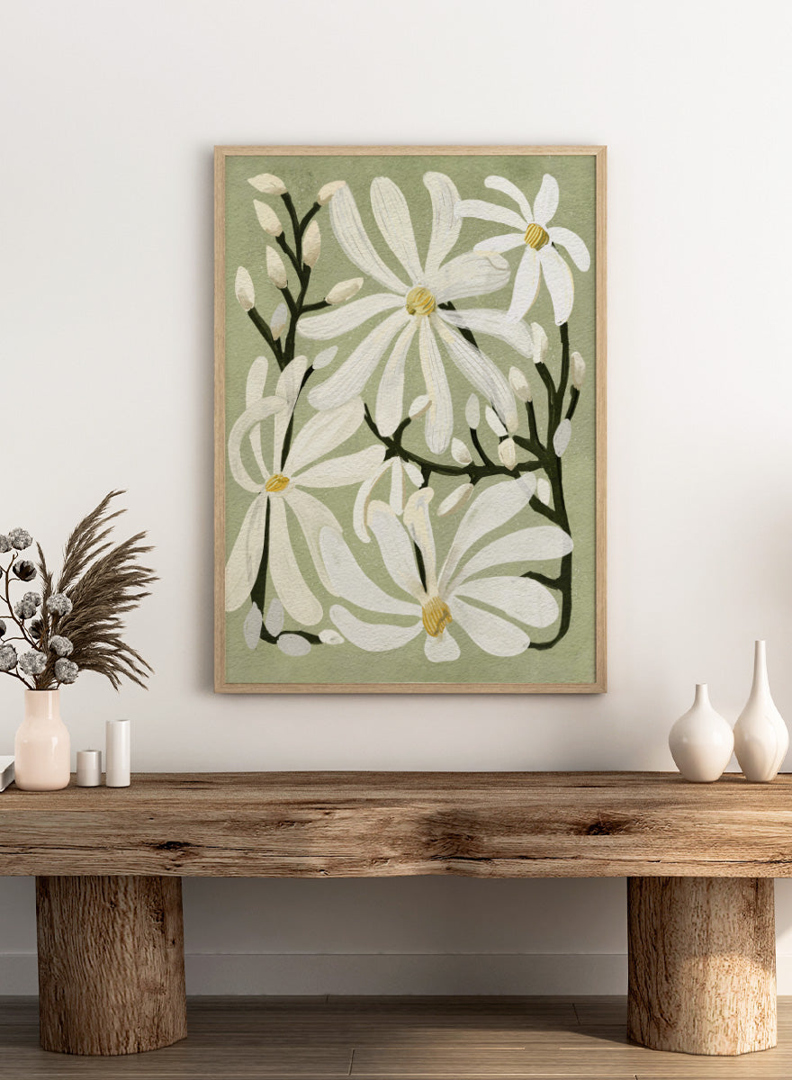 A botanical art print featuring white magnolia flowers with yellow centers and dark green stems on a muted sage green background. Shop Star Magnolia Floral Art Print by Katie O&