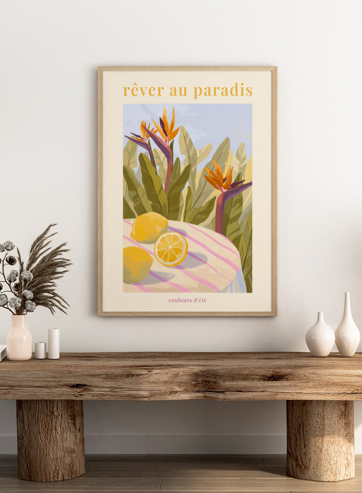 Illustration of tropical flowers and lemons with 'rêver au paradis' text on a light background. Rêver Au Paradis Lemon by Goed Blauw is a summer art print and wall poster featuring lemons, tropical leaves, and bird of paradise flowers in warm, vibrant tones.
