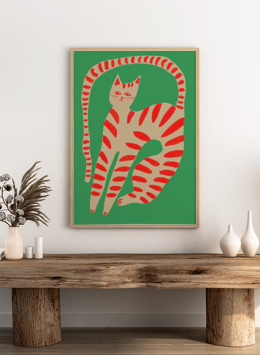 A stylized art print of a cat curled up in a circle, featuring a beige body with red stripes on a solid green background. Striped Cat Stretching by The Art Concept art print featuring a playful striped cat, green background, and bold red accents.