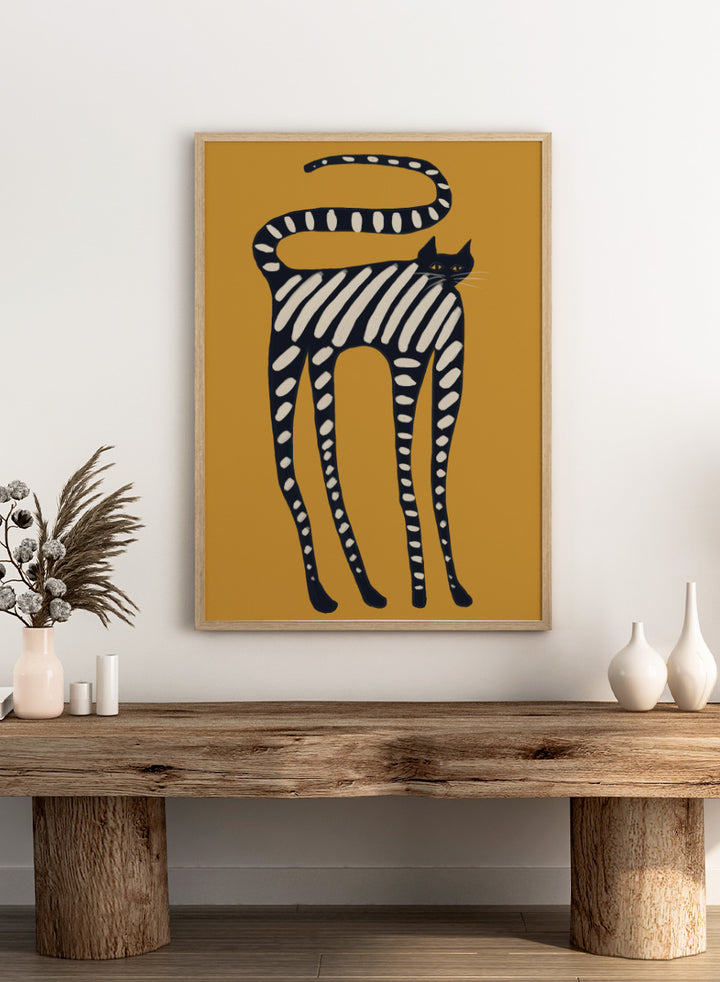 A stylized art print of a cat with black and white stripes on a mustard yellow background. Elegant Striped Cat by The Art Concept playful cat art print featuring a long black cat with cream stripes and an oversized curved tail on mustard yellow.