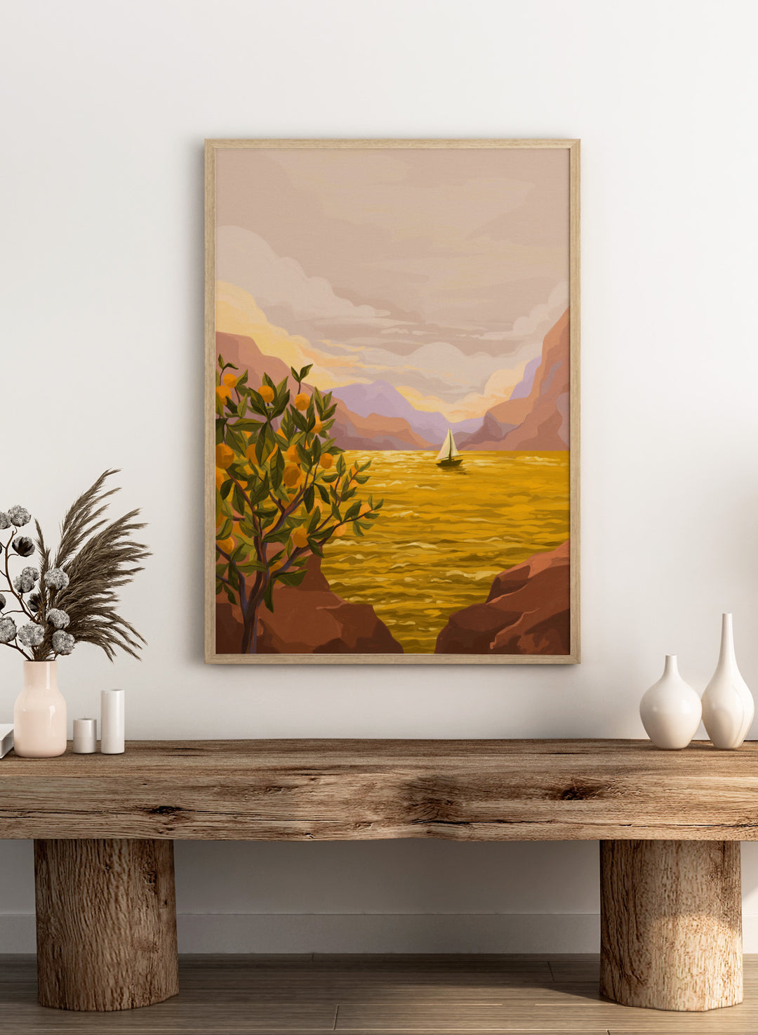 Sailing boat on a yellow sea with mountains and lemon tree in the foreground. Golden Sunset by Goed Blauw is a coastal art print and wall poster featuring a sailboat on a glowing ocean with cliffs and an orange tree.
