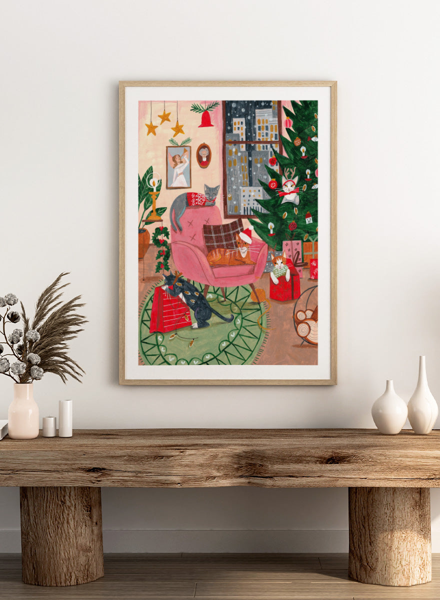 Shop Cats Home for Christmas by Caroline Bonne Müller, a festive cat wall art print poster featuring cats, a Christmas tree, presents, and a colorful holiday interior.