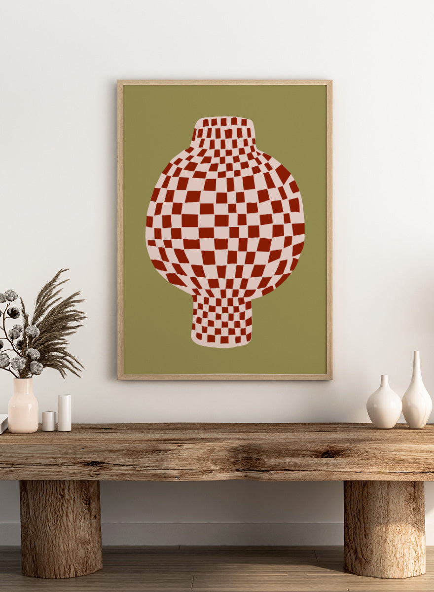 A stylized graphic print of a vase with a red and off-white checkerboard pattern, set against an olive green background. Retro Checkered Vase by The Art Concept is a modern still life art print featuring a red checkered vase, olive green background, and playful retro style.