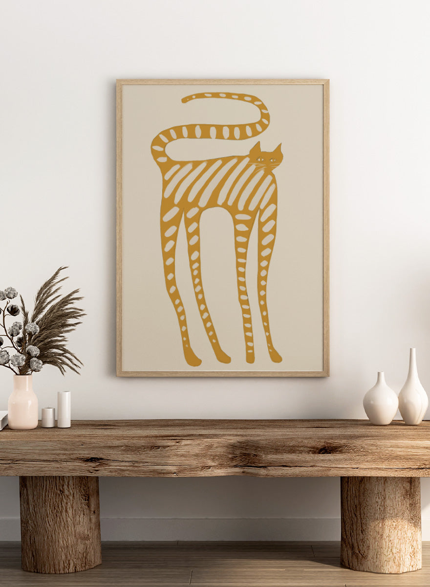 A stylized art print of a cat in a minimalist design, featuring a mustard yellow cat with white stripes and spots on a light beige background. Whimsical Striped Cat by The Art Concept cat art print featuring a mustard-yellow cat with cream stripes, long legs, and an oversized looping tail.