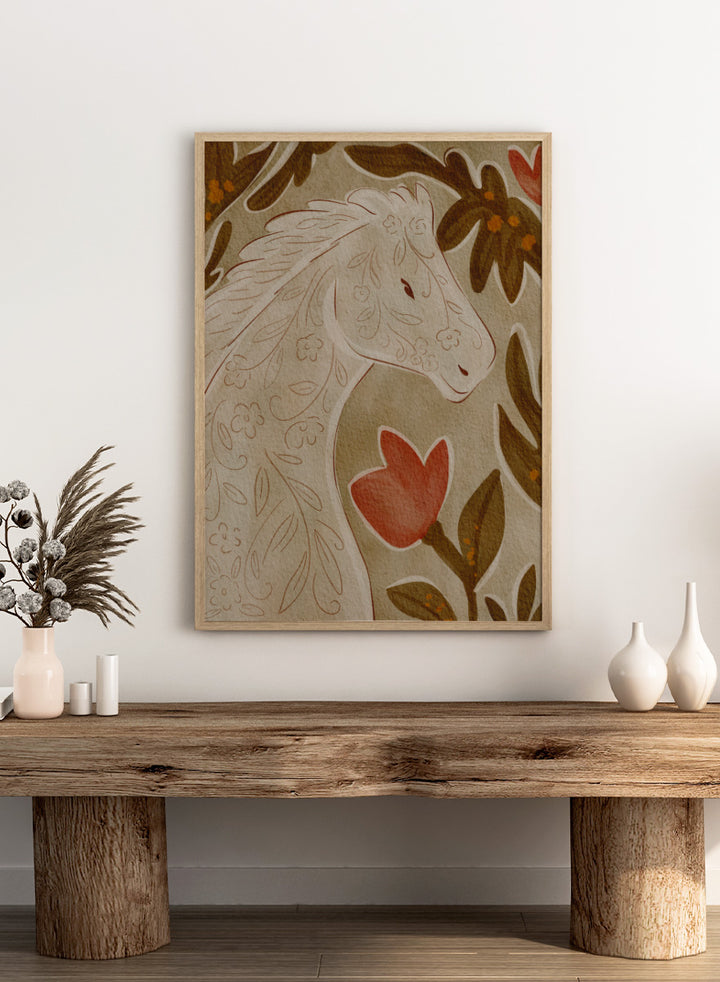 A close-up of a decorative textile or rug pattern featuring a stylized horse head in cream with floral line details, surrounded by brown leaves and a red flower on a beige background. Shop Elegant Floral Horse by Nikita Jariwala, a decorative horse wall art print featuring botanical details, folk-inspired pattern, and warm earthy neutral tones.