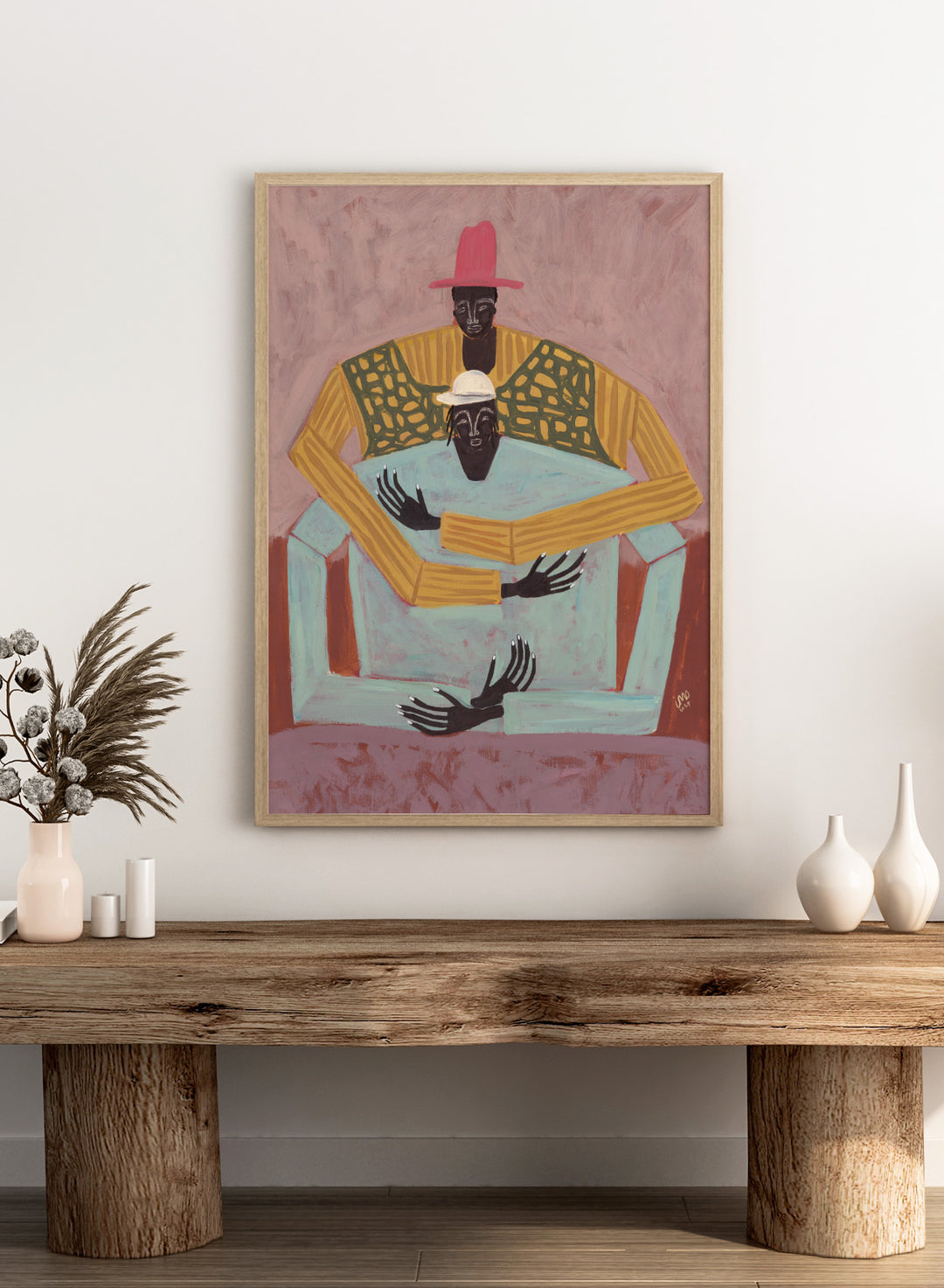 Artistic depiction of two figures sitting together with a pink background. The Hug by Studio IMO (Ibi Meier-Oruitemeka) is a modern figurative art print featuring two figures embracing in a bold contemporary wall poster design.