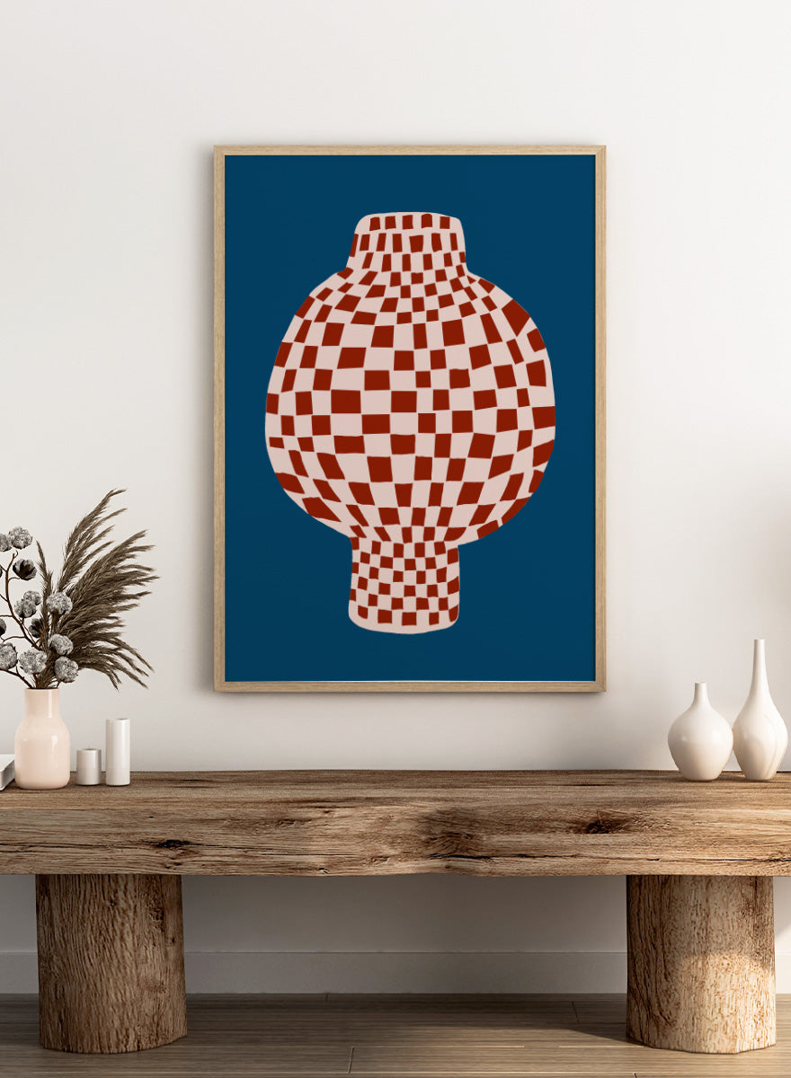 A stylized graphic illustration of a vase with a red and cream checkerboard pattern, set against a dark blue background. Optical Checkered Vase by The Art Concept is a modern still life art print featuring a red checkered vase on a deep blue background in a bold graphic style.