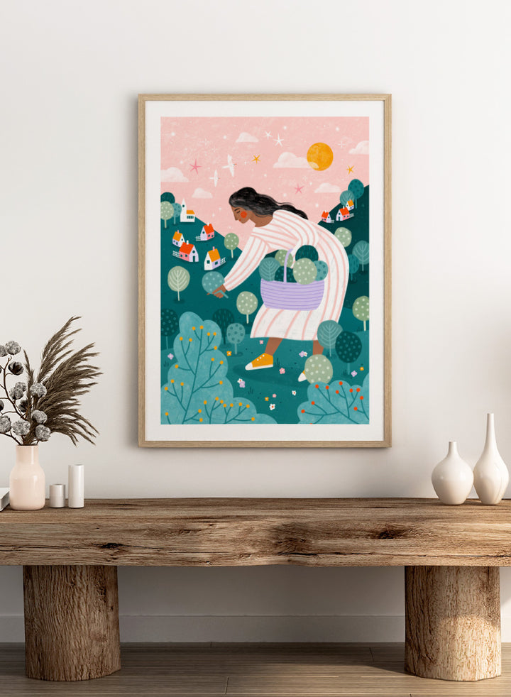 Shop Idyllic Village Gathering by Bea Müller, a figurative wall art print poster featuring a woman in a whimsical village landscape beneath a pink sky.