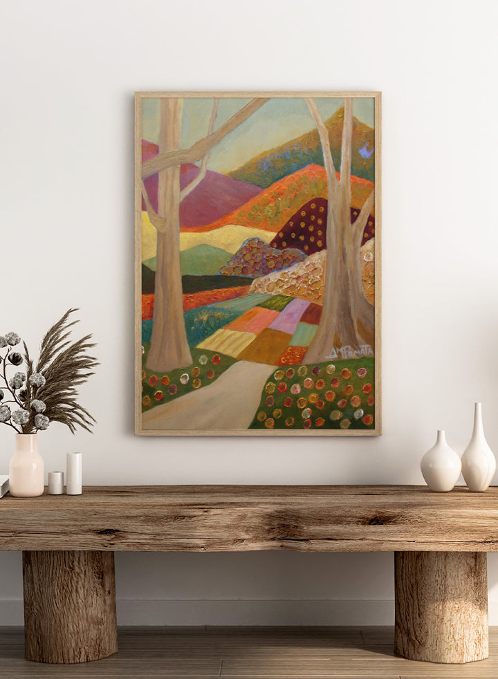 A colorful landscape painting featuring stylized trees, a winding path, patchwork fields, and rolling hills in warm and cool tones, with a visible artist signature in the lower right. Shop Colorful Field Path by Angeles M. Pomata, an autumn landscape art print featuring a winding path, textured fields, flowers, and rolling countryside.