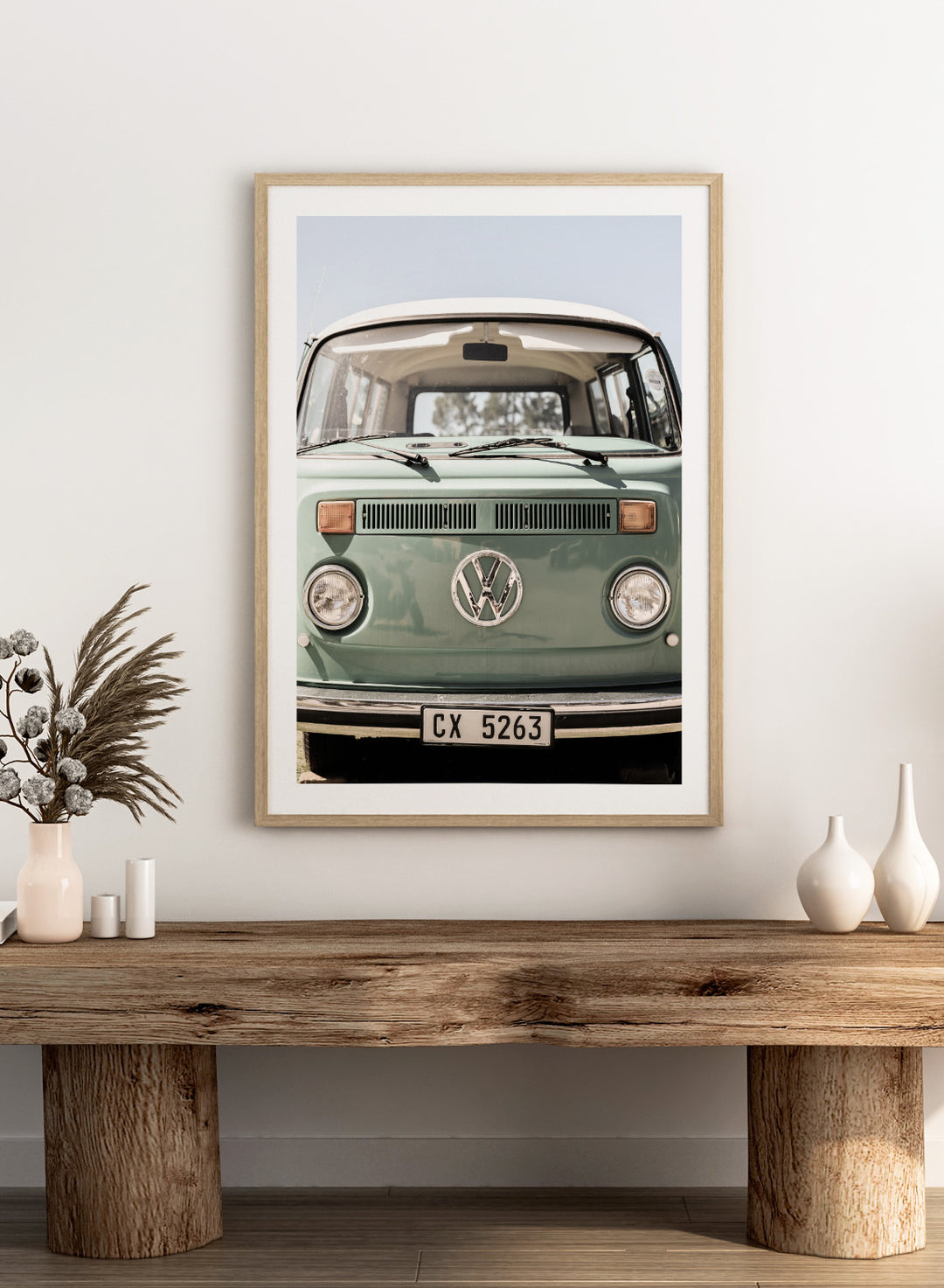 Front view of a vintage green Volkswagen van with clear sky background. Classic Design In Soft Green Tones by Shot by Clint car art print featuring a vintage Volkswagen camper van in soft sage green and warm sunlight.