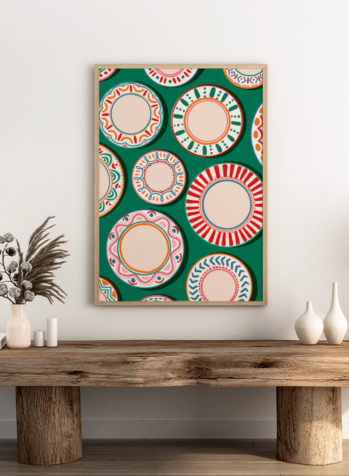A flat-lay pattern of colorful decorative plates on a dark green background, featuring a variety of circular designs in red, orange, pink, blue, and cream. Shop Colorful Patterned Plates by Nidhi Kachhadiya, a playful kitchen wall art print featuring decorative plates, folk-inspired patterns, and bold green, red, and pink tones.