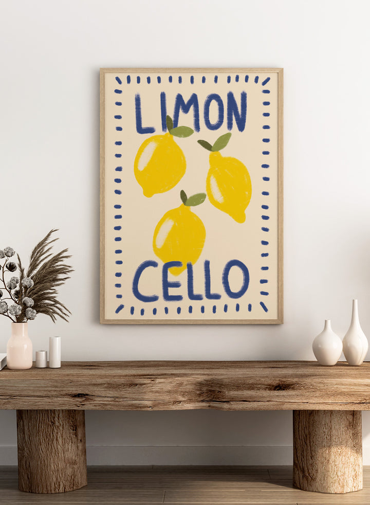 An art print featuring three yellow lemons with green leaves on a cream background, framed by a blue dotted border. The words &