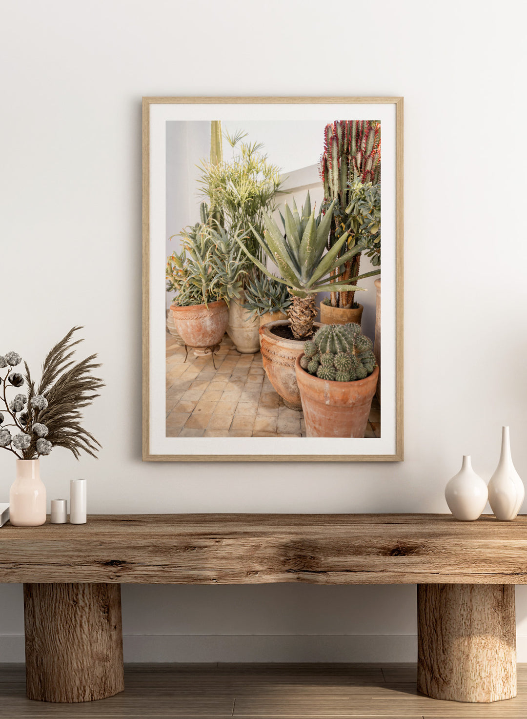 Collection of potted cacti and succulents on a patio. Sunny Desert Plant Garden by Henrike Schenk features cacti, agave, terracotta pots, and Moroccan garden styling in a warm botanical photography print.