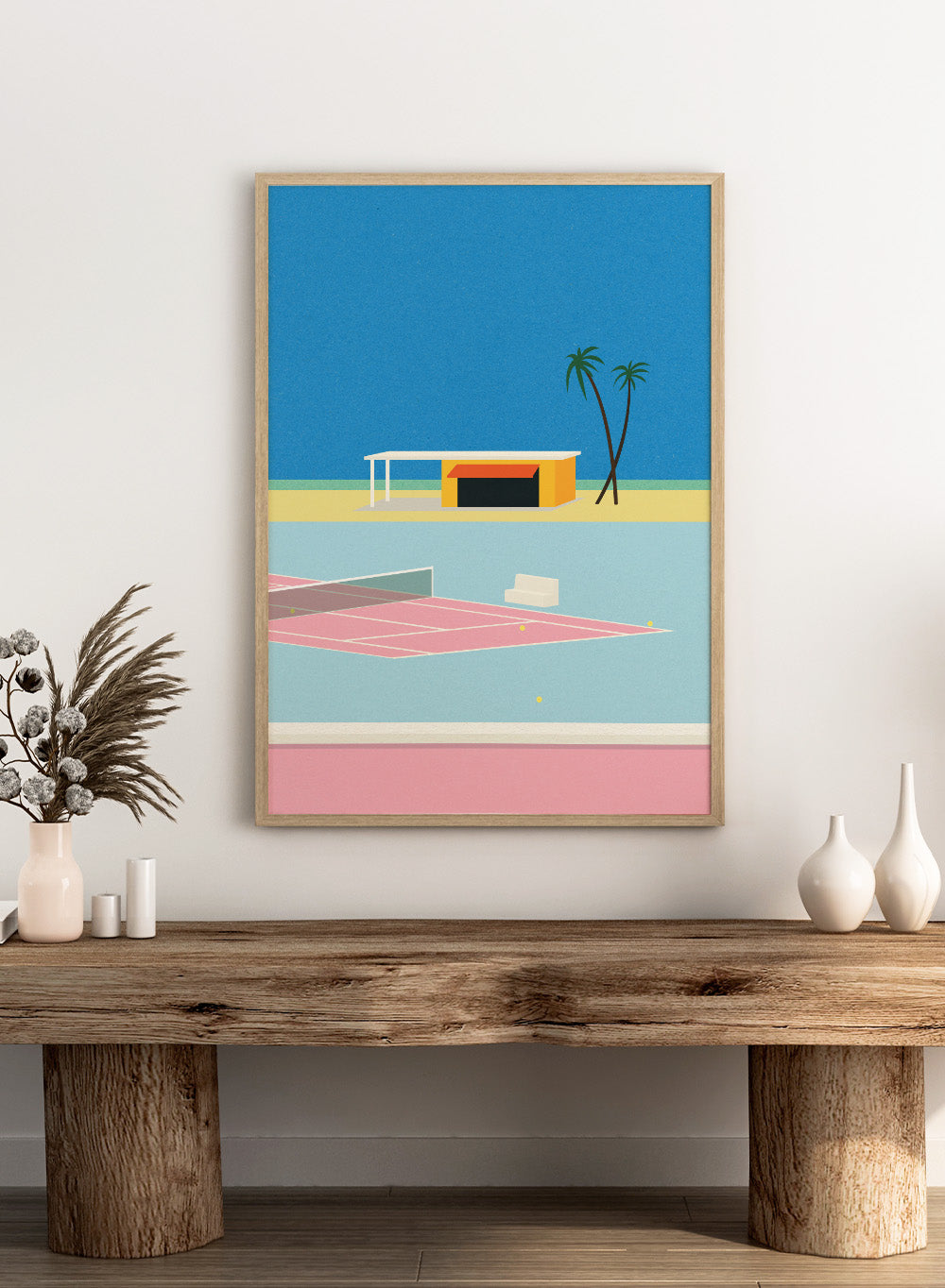 Simplified illustration of a tennis court with a small building and palm trees against a blue sky. Tennis By the Beach by Rosi Feist is a minimalist modern art print of a tennis court beside beach and palm trees. Officially licensed fine art poster with framing.