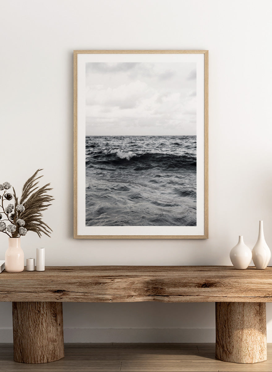 Black and white photographic art print of ocean waves under a cloudy sky. Endless Waves by Shot by Clint black-and-white ocean photography print featuring rolling water, textured surf, cloudy skies, and dramatic coastal movement.