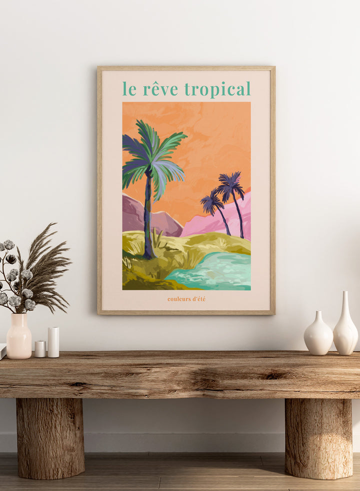 Tropical landscape with palm trees and a lake, featuring the text 'le rève tropical' on an orange background. Le Rêve Tropical Palm Trees by Goed Blauw is a tropical landscape art print and wall poster featuring palm trees, hills, and water in warm sunset tones.