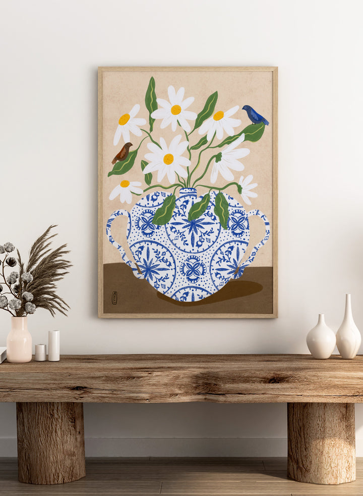 Decorative illustration of a blue and white teapot with daisies and birds on a beige background. Daisies In Blue Teapot by Dirkie Nell is a floral art print featuring white daisies, blue pottery, birds, and hand painted botanical details.