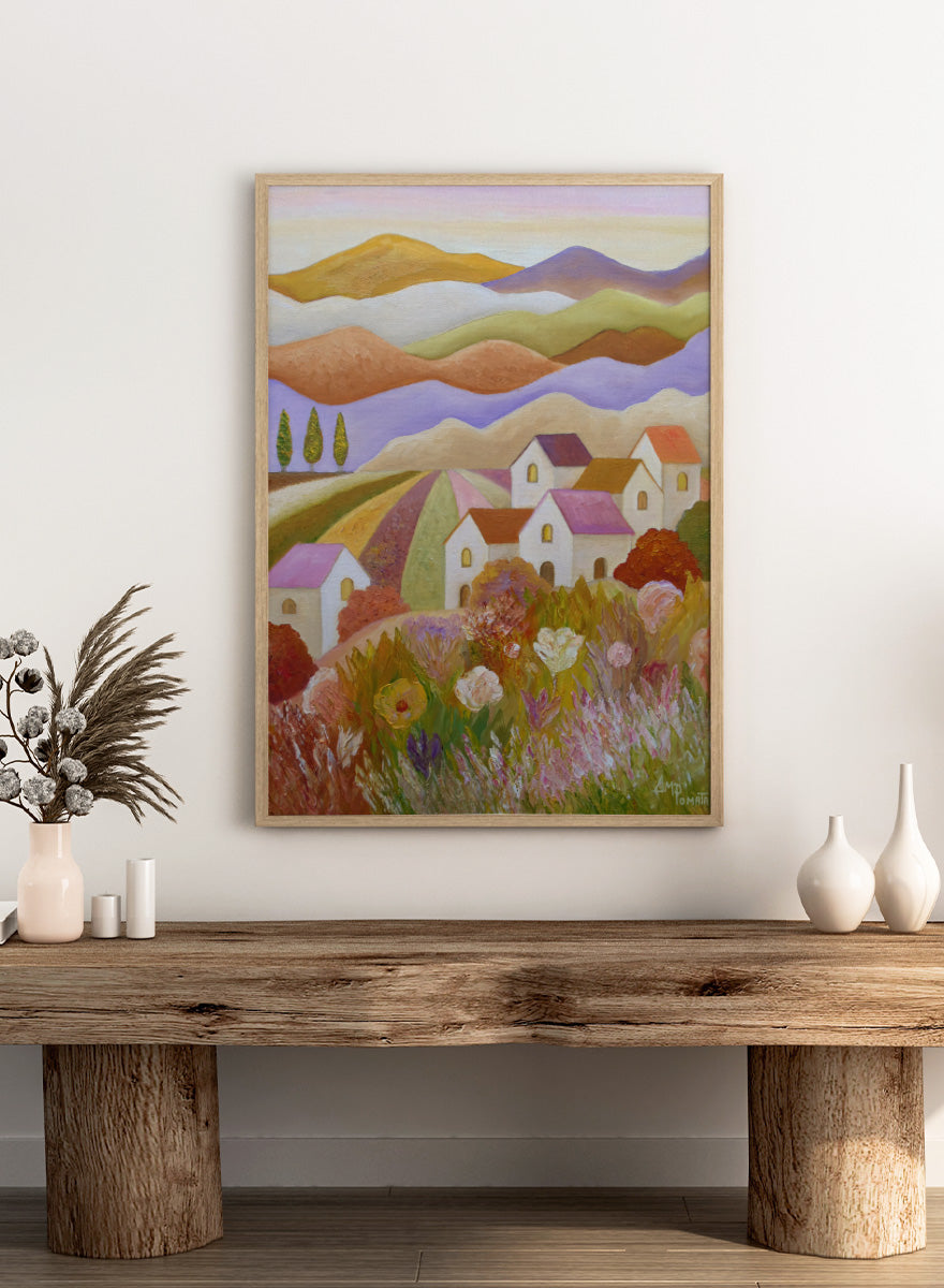 A colorful landscape painting featuring rolling hills, stylized houses, cypress trees, and wildflowers in the foreground, rendered in a painterly impressionistic style. Shop Colorful Countryside Village by Angeles M. Pomata, an autumn landscape art print featuring white houses, rolling hills, wildflowers, and warm earthy tones.