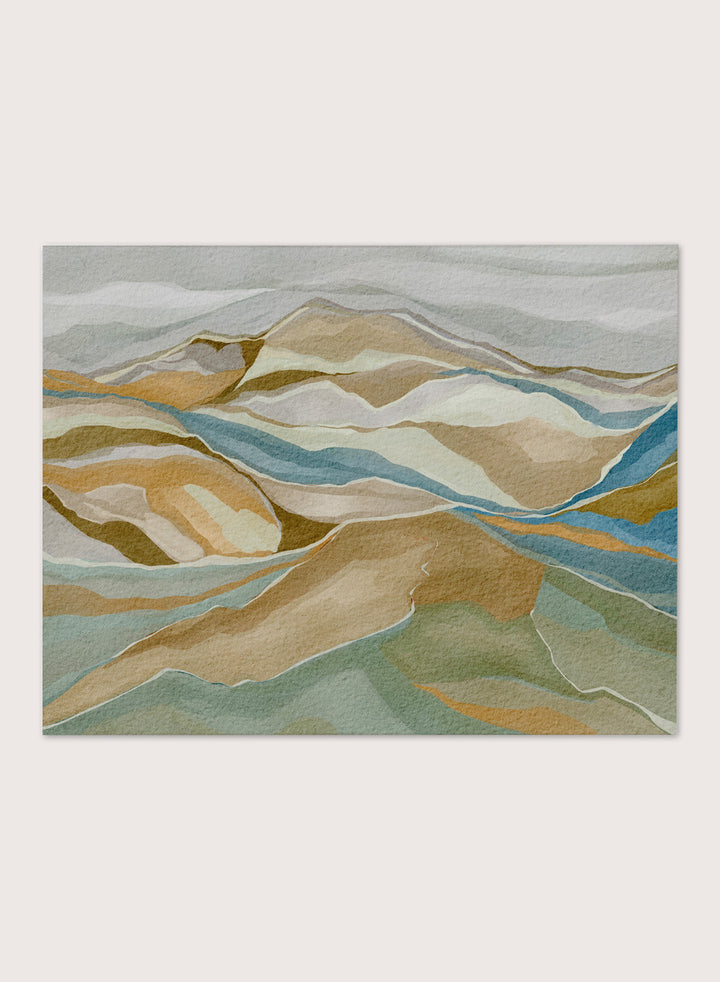 Framed abstract landscape wall art featuring layered hills and winding blue river-like lines in beige, tan, muted green, and blue tones, shown against a light neutral background. Shop Abstract Mountain Serenity by Nikita Jariwala, a modern mountain wall art print featuring layered abstract hills, earthy tones, and soft blue and sage accents.
