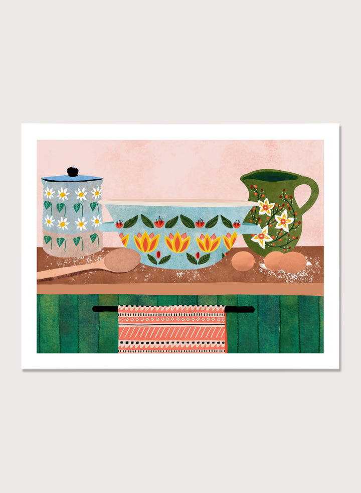 Framed art print featuring a whimsical still life illustration of kitchenware, including a floral-patterned bowl, a green pitcher, eggs, and a patterned towel. Charming Folk Kitchen by Ceyda Alasar kitchen art print featuring painted pottery, floral patterns, wooden spoons, eggs, and colorful folk-inspired decor.