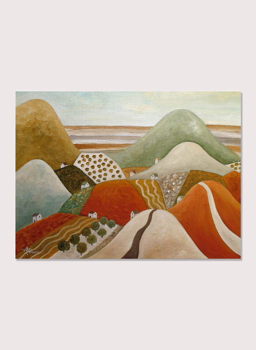 A framed landscape painting featuring stylized rolling hills and fields in earthy tones of orange, green, beige, and brown. Shop Colorful Hillside Village by Angeles M. Pomata, an autumn landscape art print featuring rolling hills, tiny homes, winding roads, and warm earthy tones.
