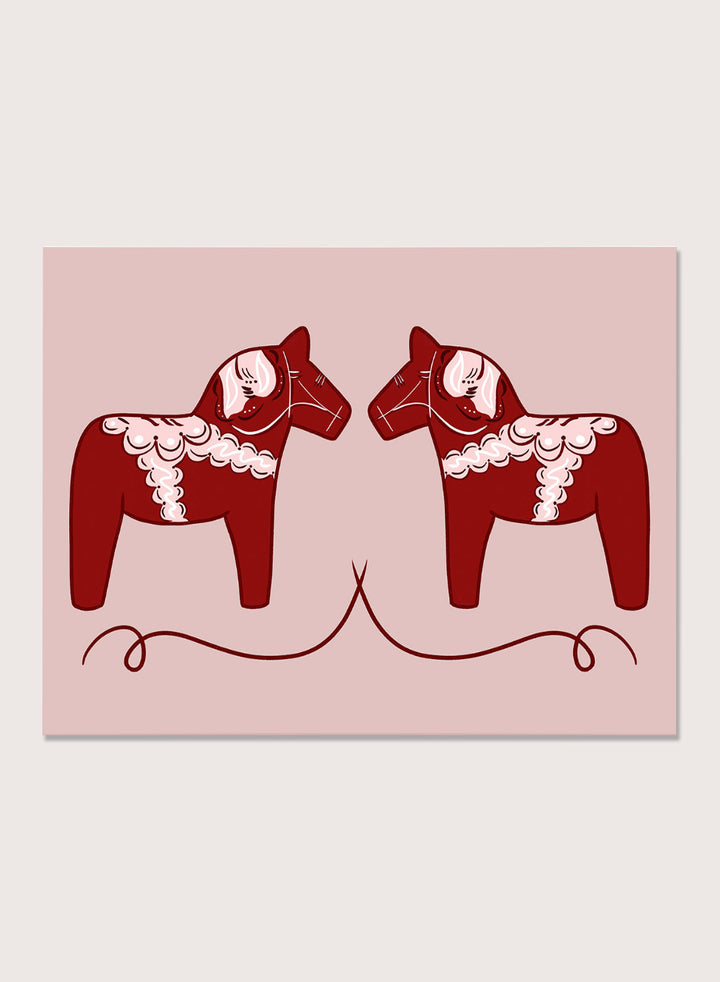 Two red Dala horse figures with white patterns on a pink background. Nordic Horses Twins by Athene Fritsch is a Scandinavian folk art illustration art print featuring Swedish Dala horses, bold red color, and modern wall art design.