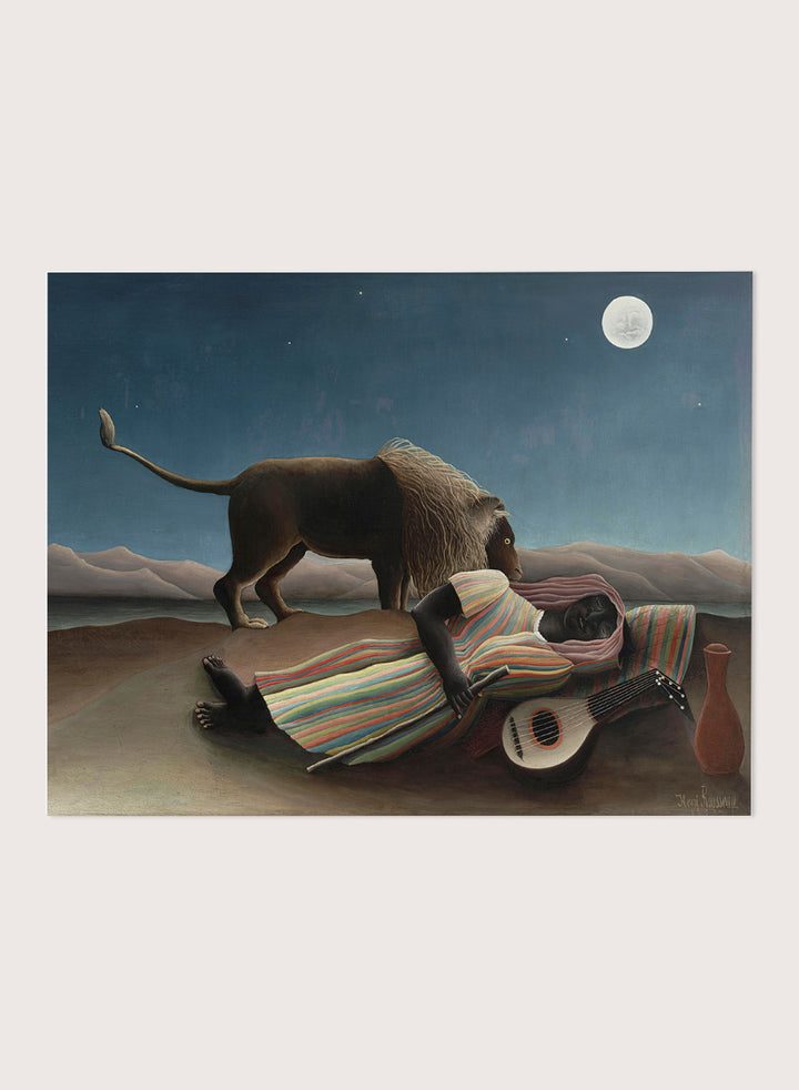 A framed surreal art print depicting a lion standing over a sleeping person wrapped in a striped blanket, with a guitar, vase, and full moon in a night sky. The Sleeping Gypsy by Henri Rousseau is a vintage art print featuring a sleeping traveler, lion, moonlit desert, striped robe, mandolin, and deep blue night sky.