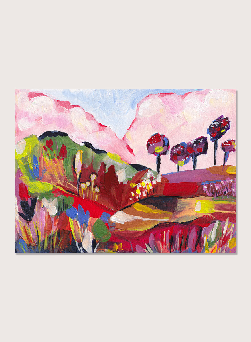 A framed abstract landscape painting featuring pink clouds, green hills, and colorful stylized trees. Shop Vibrant Fantasy Landscape by Dirkie Nell, a colorful landscape art print featuring pink clouds, rolling hills, wildflowers, and bold abstract color.